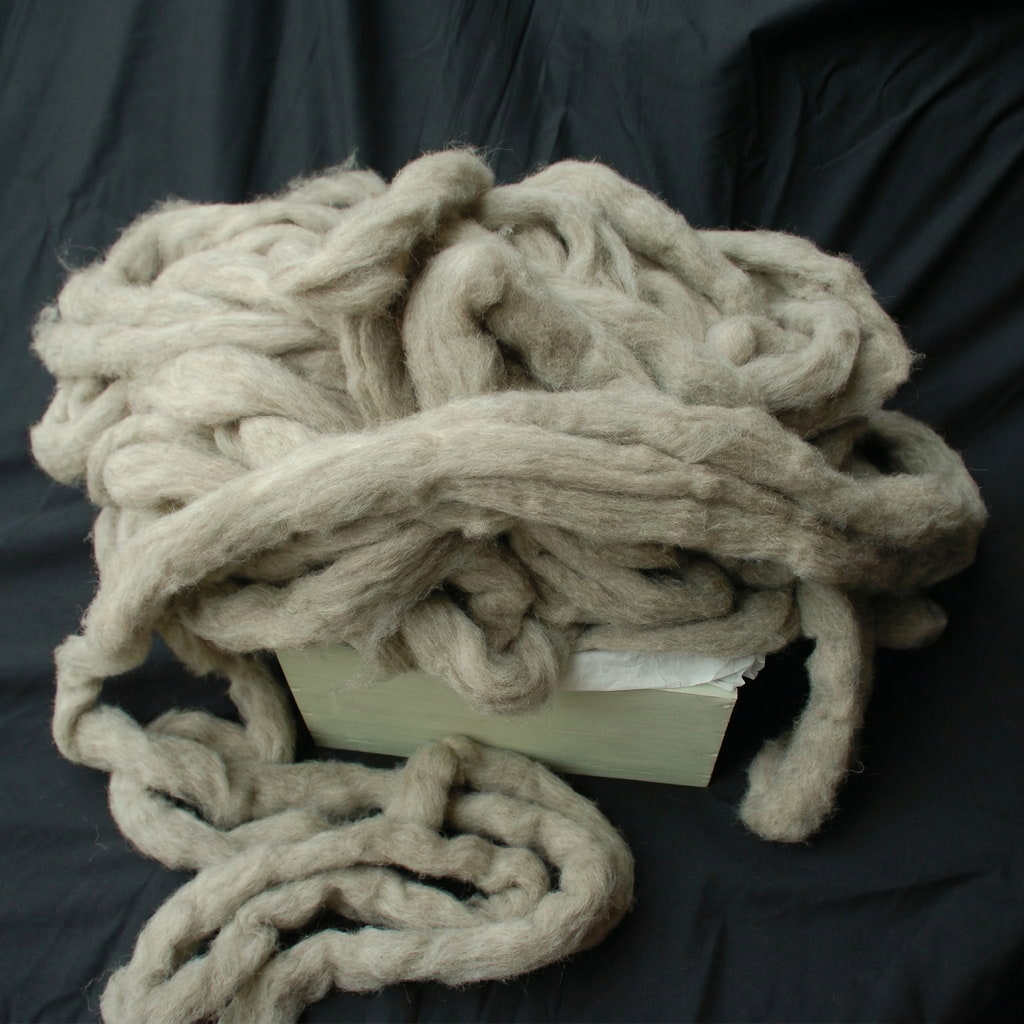 Coiled beige roving on a black background