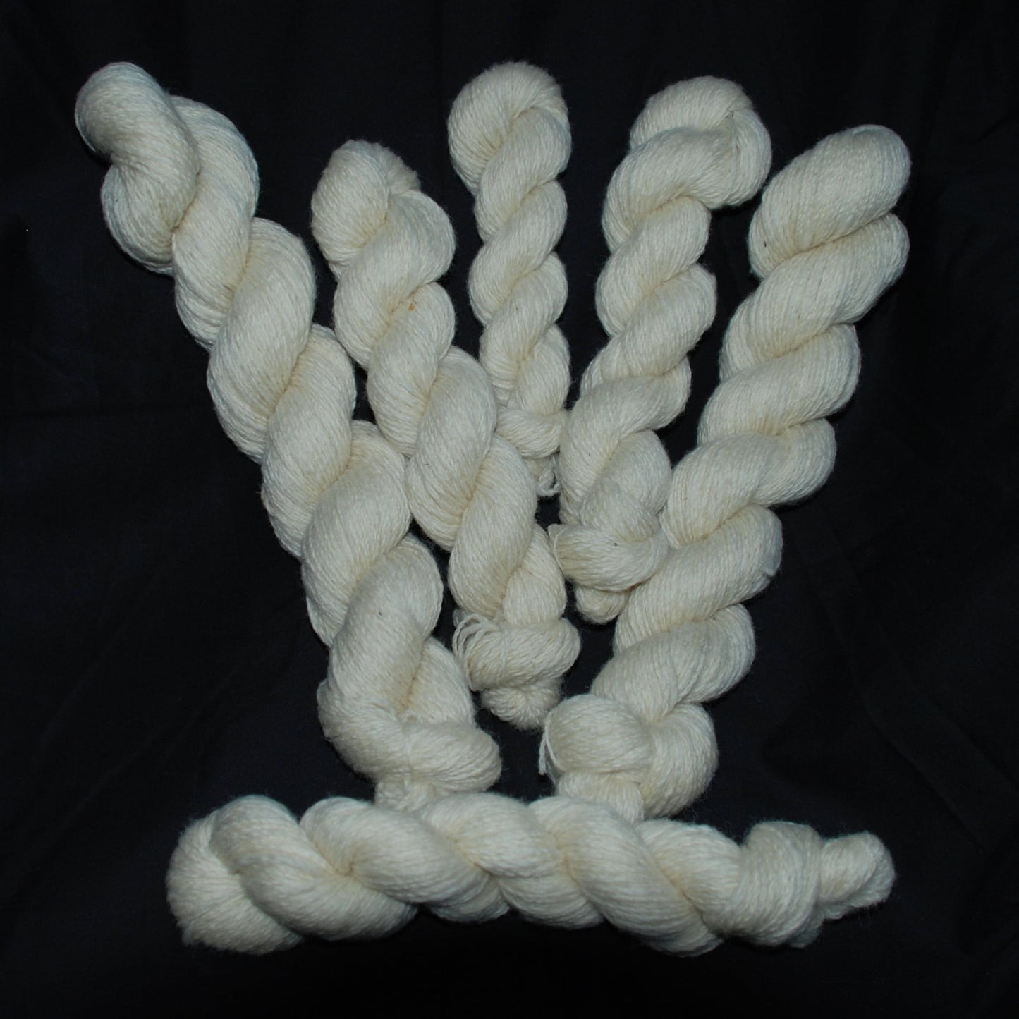 Natural white Romney wool yarn on a black background