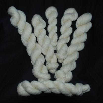 Natural white Romney wool yarn on a black background