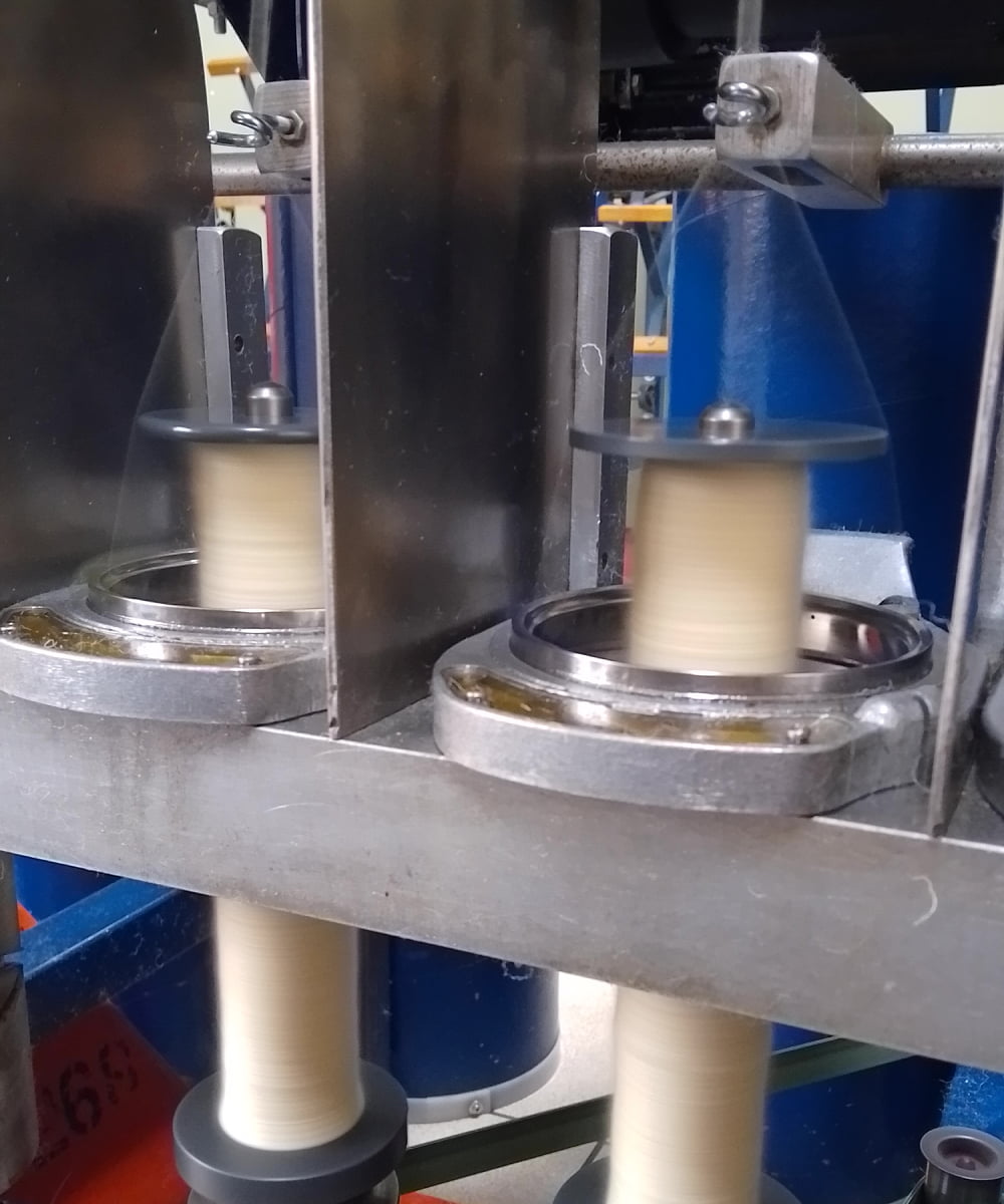 Close-up of a fibres being spun onto bobbins